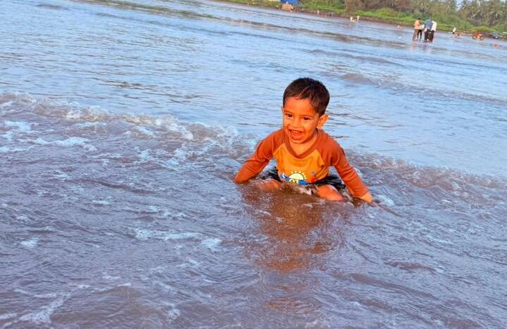 Child gazing at calm sea waves layered to the horizon